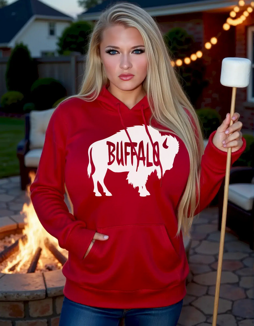 Beautiful woman wearing red Buffalo hoodie by bonfire at night holding marshmallow stick during chilly Buffalo weather.