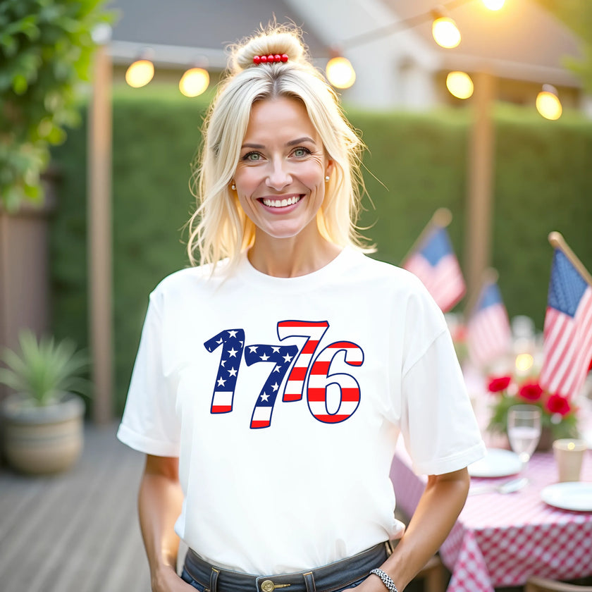 Female model wearing white 1776 patriotic t-shirt outdoors, bold flag-filled numbers design, celebrating Independence Day with casual summer Fourth of July vibe