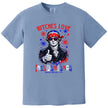Patriotic Jefferson graphic tee in blue with ‘Bitches Love Independence’ text, sunglasses, bandana, and fireworks background for July 4th.