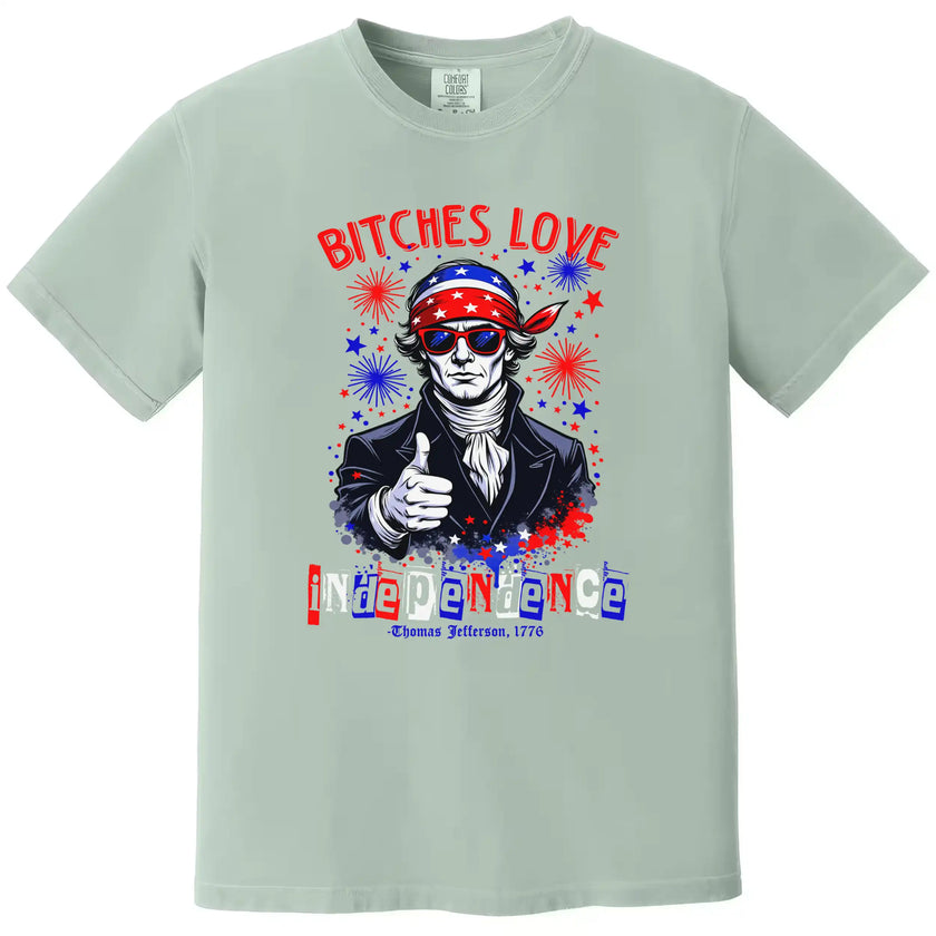 Bold Independence Day graphic tee in green featuring ‘Bitches Love Independence’ with Thomas Jefferson, sunglasses, bandana, and sparkles