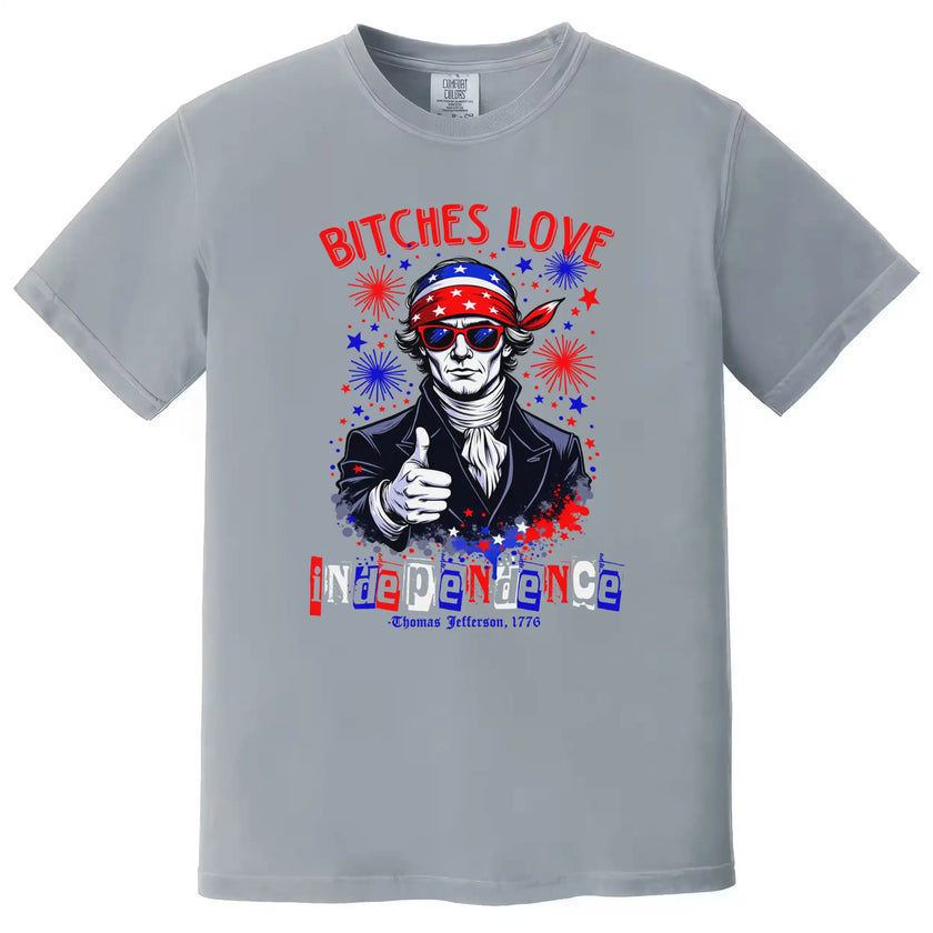 Edgy July 4th shirt in gray reading ‘Bitches Love Independence’, Thomas Jefferson wearing sunglasses with patriotic bandana and fireworks design