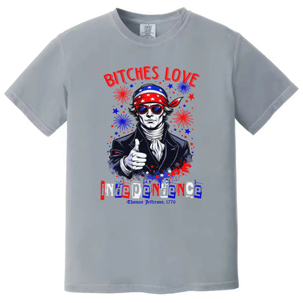 Edgy July 4th shirt in gray reading ‘Bitches Love Independence’, Thomas Jefferson wearing sunglasses with patriotic bandana and fireworks design