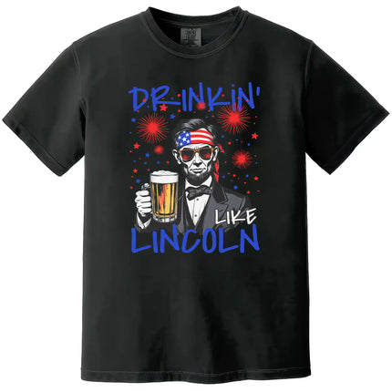 Drinkin Like Lincoln patriotic t-shirt in black, featuring Abraham Lincoln wearing sunglasses and bandana holding a beer mug, funny July 4th graphic tee.