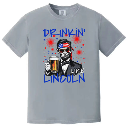 Drinkin Like Lincoln patriotic t-shirt in gray, humorous Lincoln graphic with beer mug and patriotic accessories, July 4th BBQ and party shirt.