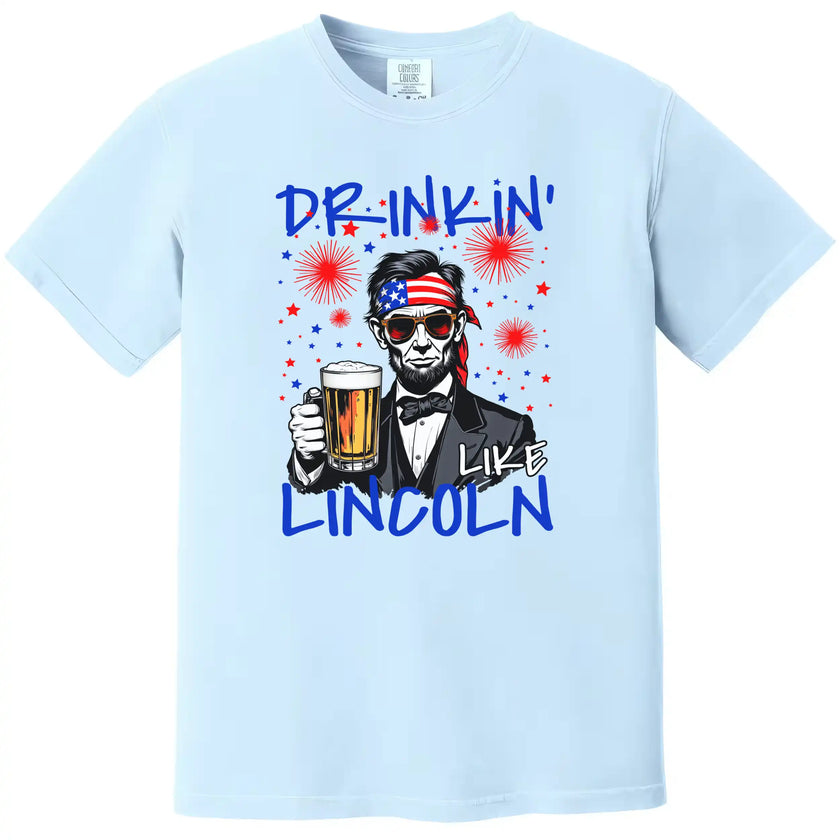 Drinkin Like Lincoln patriotic t-shirt in light blue, Abraham Lincoln wearing sunglasses and bandana holding beer, fun Independence Day graphic tee