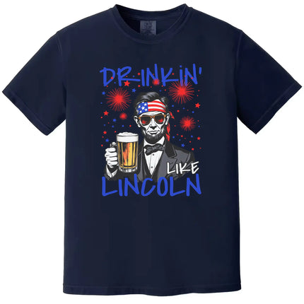 Drinkin Like Lincoln patriotic t-shirt in navy, bold Lincoln drinking graphic with sunglasses and bandana, funny Fourth of July beer tee.
