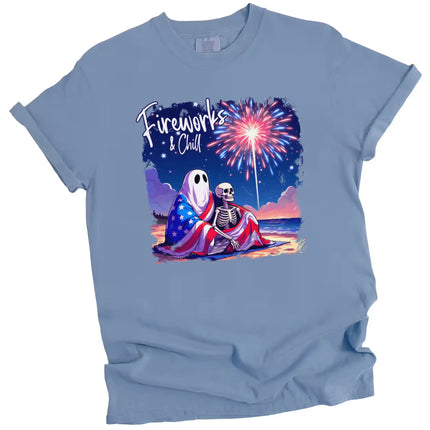 Fireworks and Chill patriotic t-shirt in blue, cute ghost and skeleton beach scene with fireworks and flag blanket, playful July 4th graphic tee