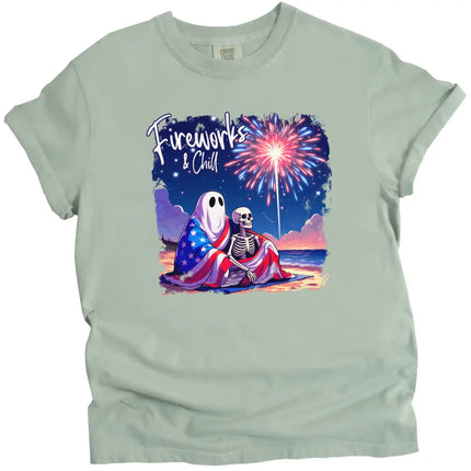 Fireworks and Chill patriotic t-shirt in green, cute spooky couple under American flag blanket watching fireworks, relaxed July 4th beach night graphic tee.