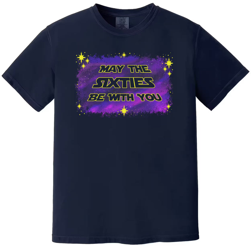 Navy “May the Sixties Be With You” birthday t-shirt flat lay featuring retro galaxy yellow lettering on purple and blue starry background