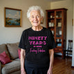 Woman wearing black ‘90 Years of Being Fucking Fabulous’ birthday t-shirt with bold pink mixed-font lettering, confident and playful 90th birthday celebration vibe.