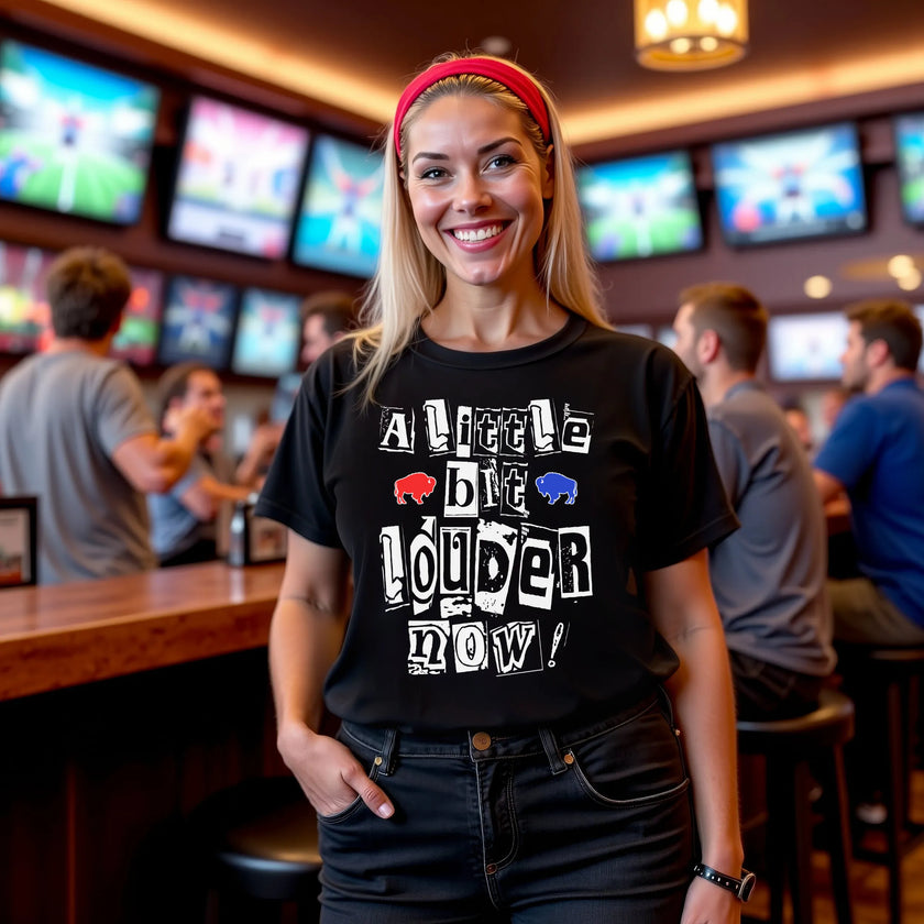 Woman wearing a black Buffalo football t-shirt with the ‘A Little Bit Louder Now’ game-day chant in magazine cutout lettering and a small red and blue buffalo graphic, celebrating Buffalo fan tradition.
