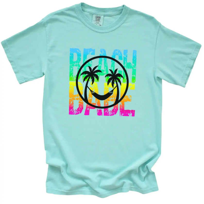 Summer Beach Babe tee in mint, neon rainbow distressed text with palm tree smile face and hammock design, tropical vacation shirt.