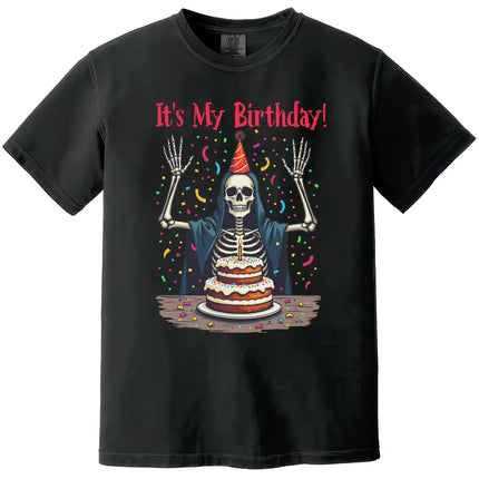 Black “It’s My Birthday” skeleton t-shirt flat lay with skeleton wearing party hat and cloak, surrounded by confetti, fun birthday tee