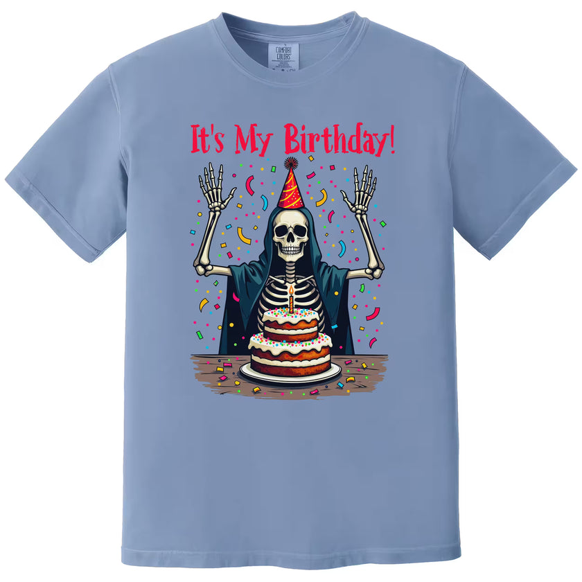 Blue “It’s My Birthday” skeleton t-shirt flat lay featuring skeleton with party hat and falling confetti, bold and playful birthday graphic