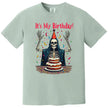 Green “It’s My Birthday” skeleton t-shirt flat lay with festive skeleton illustration and confetti, fun birthday party design