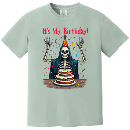 Green “It’s My Birthday” skeleton t-shirt flat lay with festive skeleton illustration and confetti, fun birthday party design