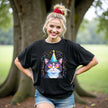 Female model wearing black birthday cat t-shirt outdoors, party animal cat with sunglasses, hat, and colorful confetti celebration design.