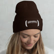 Woman wearing a brown football-inspired cuffed beanie featuring white embroidered detailing on the front, cozy cold-weather accessory with subtle Buffalo football style.