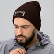 Man wearing a brown cuffed football beanie with distinctive white embroidered football-inspired design across the front, stylish winter hat for Buffalo football fans.
