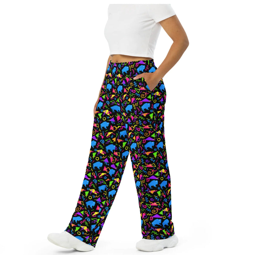 Side view of Buffalo NY patterned pants with bright neon geometric shapes, retro arcade-inspired print, and blue buffalo silhouettes in a bold all-over design.