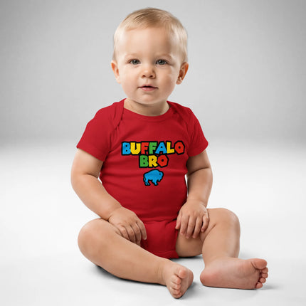 Baby wearing red Buffalo Bro baby bodysuit featuring retro gaming inspired lettering and buffalo logo graphic, front view nostalgic baby outfit.