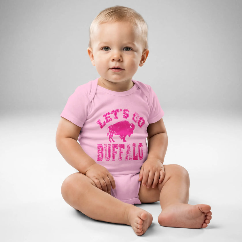 Baby wearing pink Buffalo football ‘Let’s Go Buffalo’ bodysuit with distressed hot pink lettering and buffalo silhouette graphic, front view.