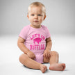 Baby wearing pink Buffalo football ‘Let’s Go Buffalo’ bodysuit with distressed hot pink lettering and buffalo silhouette graphic, front view.