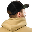 Man viewed from behind wearing a Buffalo Football camo trucker hat showcasing the breathable mesh back, adjustable fit, and classic casual style.