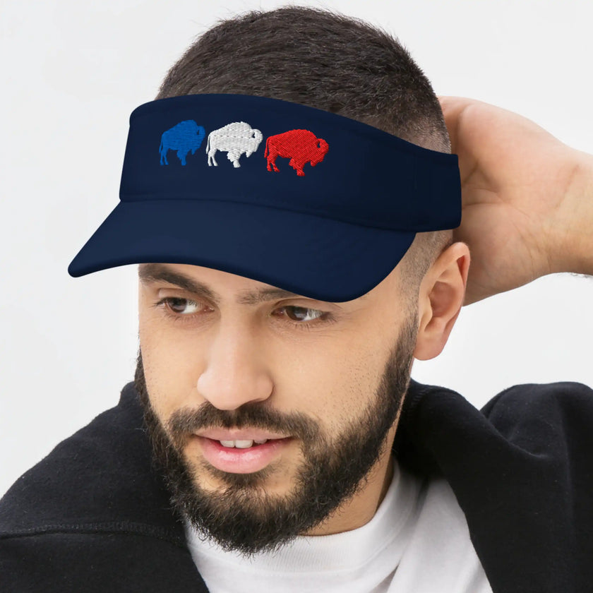 Man wearing a navy Buffalo football golf visor featuring three embroidered buffalo silhouettes in red white and blue, sporty headwear for golf, sunshine, and casual wear.