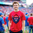 Male model weraing red buffalo mascot football shirt with zebra-stripe sunglasses and puffball winter hat. Bold fan style for men at the game.