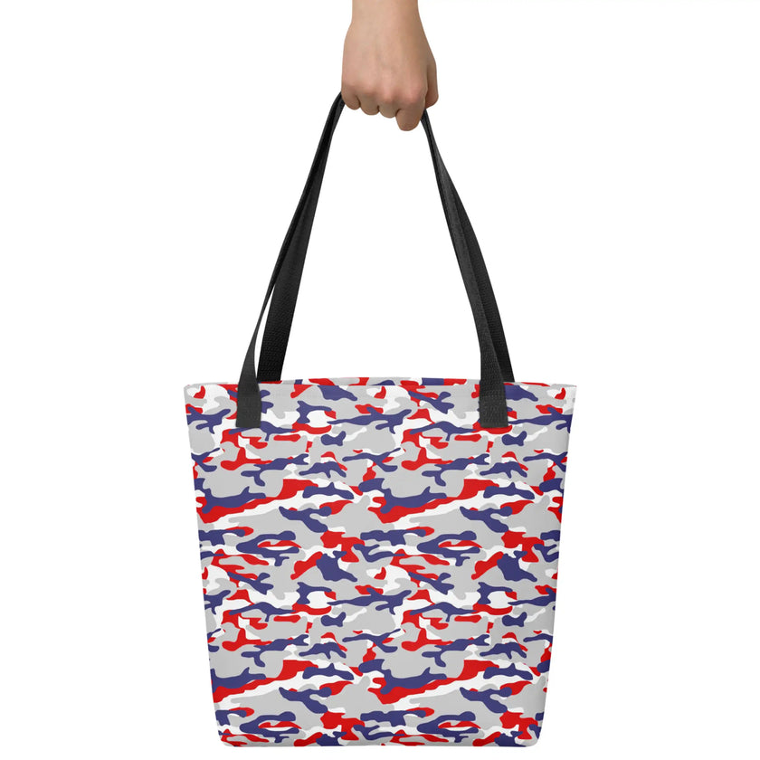 Hand holding a Buffalo football camouflage tote bag featuring an original red white blue and grey team-color pattern, standout fan accessory for everyday use.
