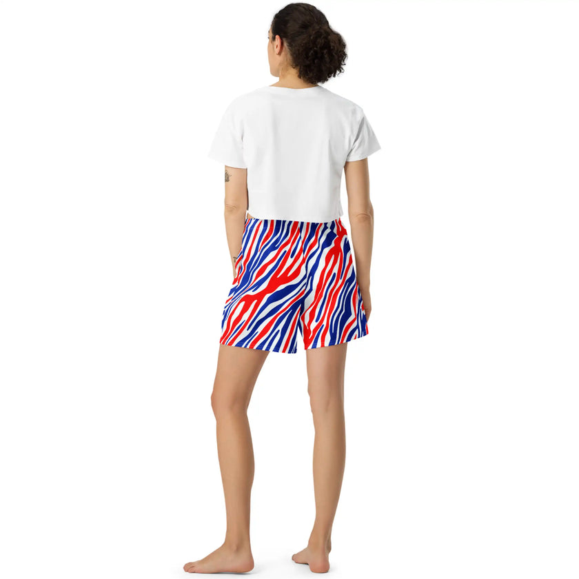 Woman posing from behind in signature Buffalo football athletic shorts with an eye-catching red white and blue stripe pattern, bold fan fashion designed for movement and standout style.