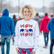 Female model wearing white Buffalo football coquette sweatshirt standing outside in the snow, showing cozy winter fan style