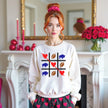 Female model wearing white Buffalo football Valentine sweatshirt standing in cozy living room