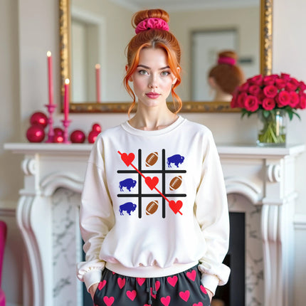 Female model wearing white Buffalo football Valentine sweatshirt standing in cozy living room