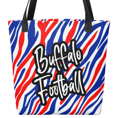 Close up view of Buffalo football tote bag featuring red white and blue striped design with fancy Buffalo Football lettering and black handles, all-over-print daily carryall.