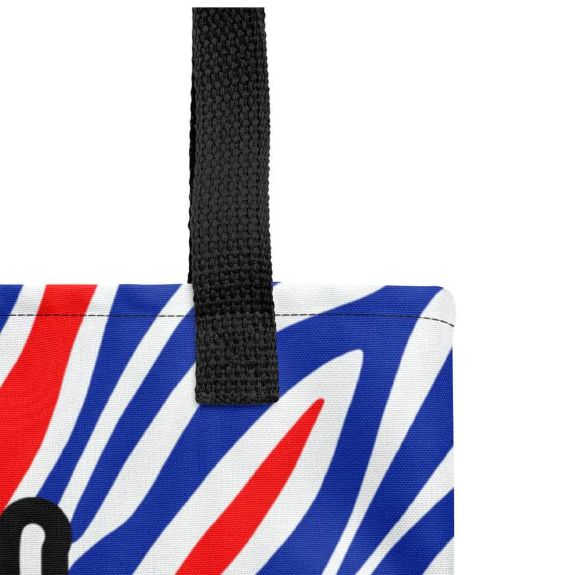 Close up view of Buffalo football tote bag with red white and blue striped all-over-print design and durable black handles and stitching.
