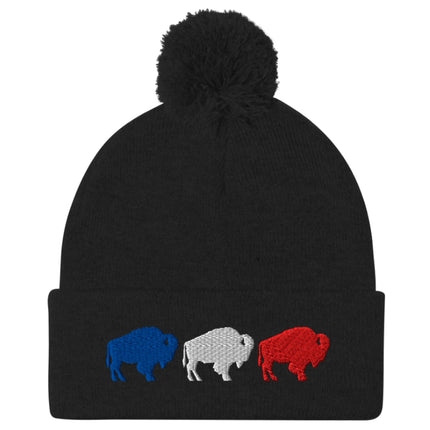 Black pom pom winter beanie featuring embroidered red white and blue Buffalo football trio silhouettes in a row, Buffalo fan winter hat design.