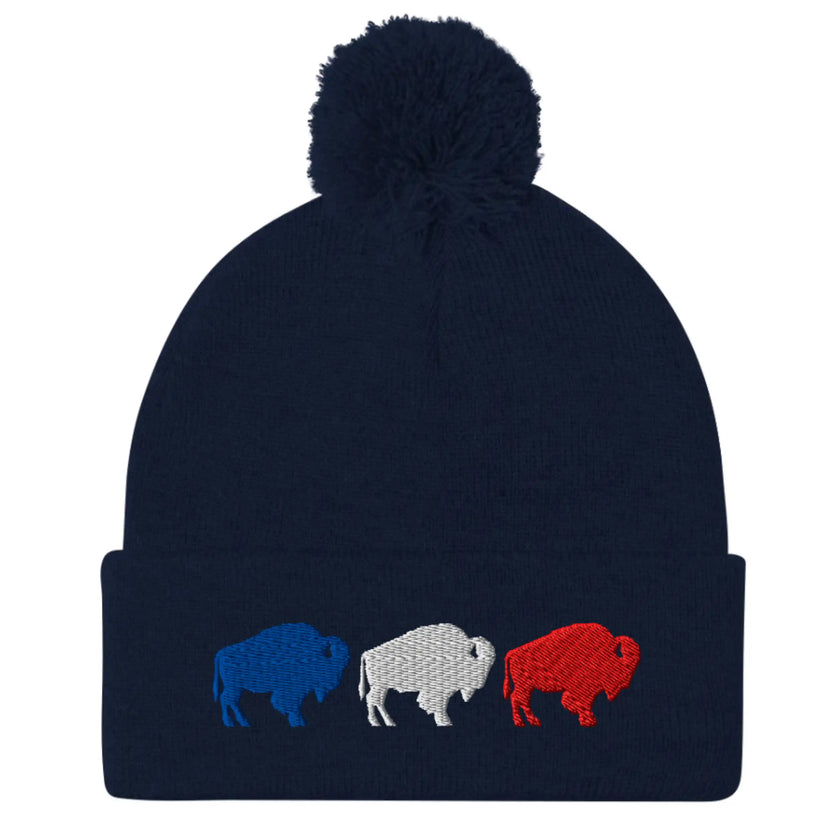Navy puffball pom pom beanie with embroidered red white and blue Buffalo football trio silhouettes, warm Buffalo sports winter hat