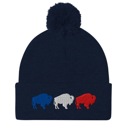 Navy puffball pom pom beanie with embroidered red white and blue Buffalo football trio silhouettes, warm Buffalo sports winter hat