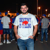 White Destiny Is Calling Buffalo football shirt with distressed blue lettering and red buffalo graphic worn by male model at a night time tailgate in the parking lot.