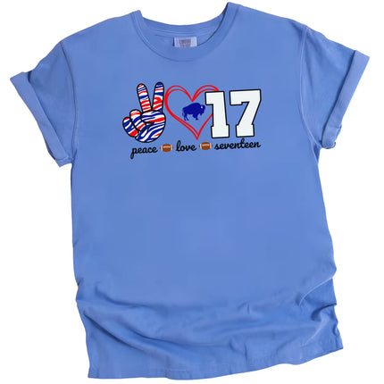 Blue football quarterback peace Love 17 t-shirt with striped peace sign, red heart, and number graphic, flat lay on white background.