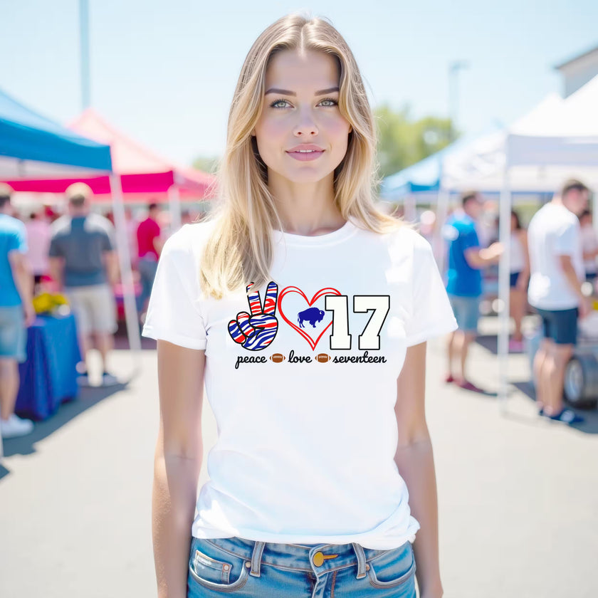 Woman wearing white Peace Love 17 t-quarterback shirt at a Buffalo street festival, showing football pride and city spirit.