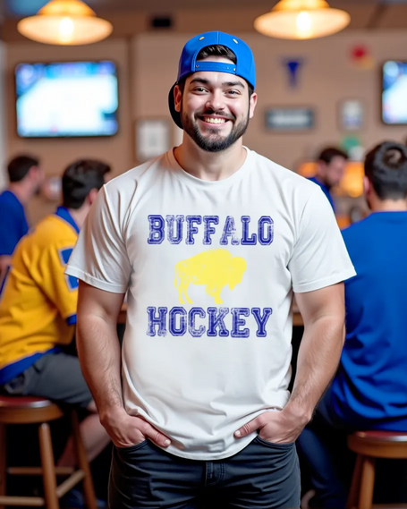 College male model posing casually at a sports bar for game night while wearing a white Buffalo hockey t-shirt and blue jeans, highlighting modern Buffalo hockey fan apparel.