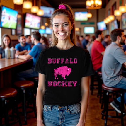 Female model wearing black Buffalo hockey t-shirt with hot pink lettering and buffalo silhouette graphic, cute sporty fan outfit.