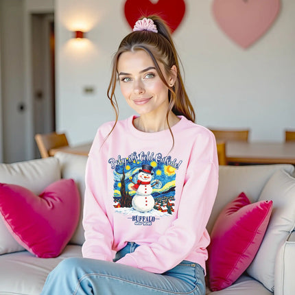 Female model wearing pink Buffalo winter snowman sweatshirt sitting on couch in cozy living room setting