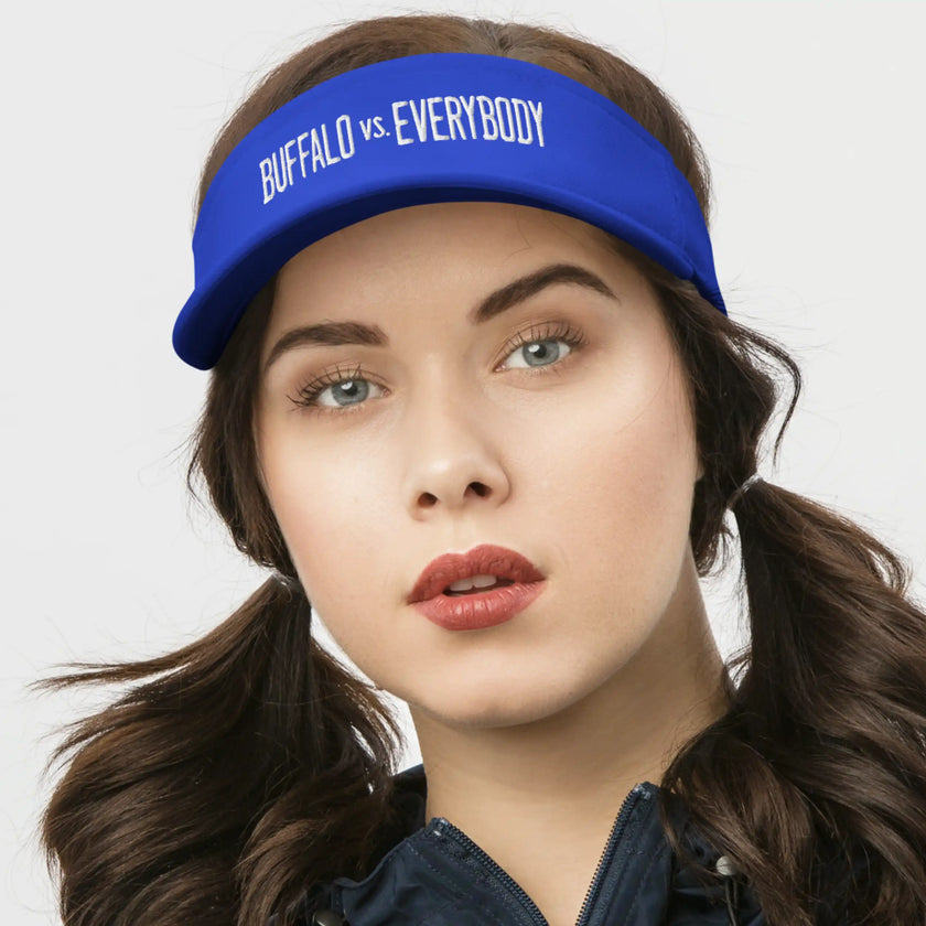 Woman wearing a blue Buffalo football golf visor featuring white ‘Buffalo vs. Everybody’ embroidery, sporty and stylish headwear for golf, sunshine, and game day.
