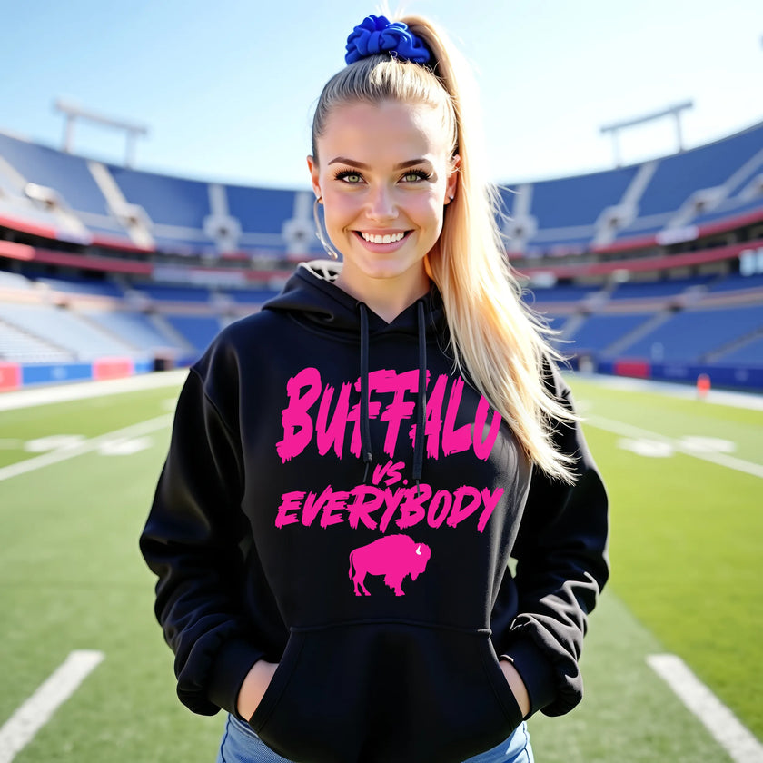 Female model wearing black Buffalo football hoodie featuring hot pink ‘Buffalo vs. Everybody’ lettering with matching buffalo silhouette, bold Buffalo football fan style.