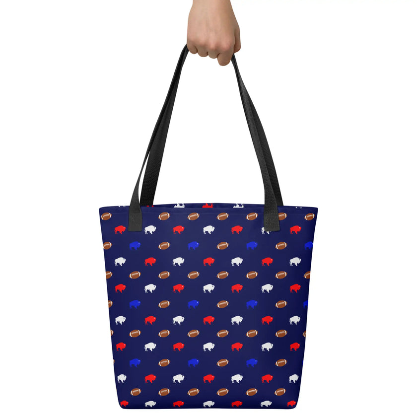 Hand holding a cute Buffalo football tote bag covered in tiny red white and blue buffaloes and brown footballs, versatile everyday carryall for groceries, shopping, or personal essentials.