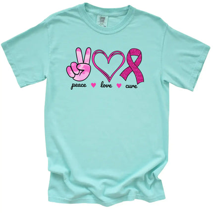 Mint “Peace, Love, Cure” t-shirt flat lay with pink tie-dye hand, double-heart, and glittery ribbon icons for awareness and advocacy